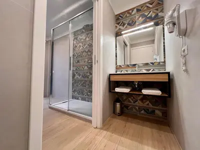 a bathroom with a walk in shower and a mirror at Trastevere Tre Porte Apartments in Rome