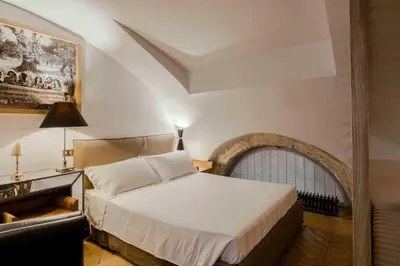 a bedroom with a white bed and a chair at Piazza Navona Luxury Loft in Rome