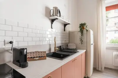 a white kitchen with a sink and a refrigerator at La Casina 348 in Rome