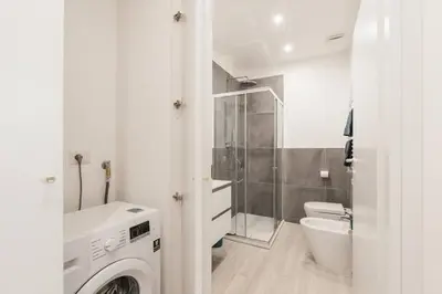 a bathroom with a sink and a washing machine at La Casina 348 in Rome