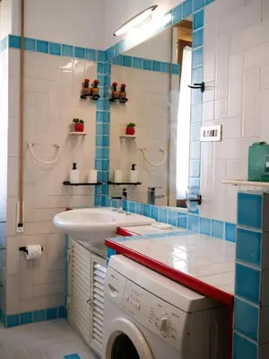 a bathroom with a sink and a washing machine at Chic and Spacious Rome Penthouse in Rome