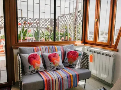 a couch sitting in a room with a window at Chic and Spacious Rome Penthouse in Rome