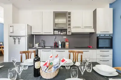 a kitchen with a table with plates and wine glasses at One's Place in Rome