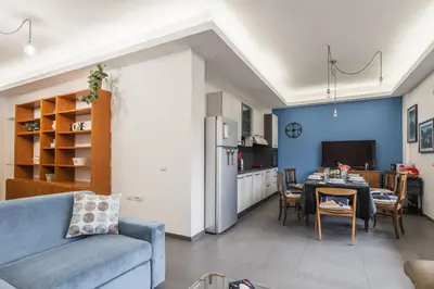 a living room with a table and a kitchen at One's Place in Rome