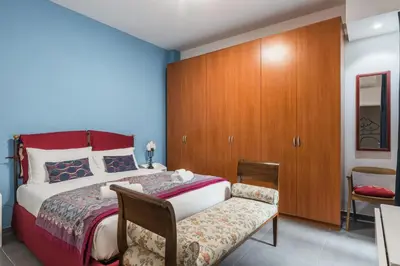 a bedroom with a bed and a chair and a cabinet at One's Place in Rome