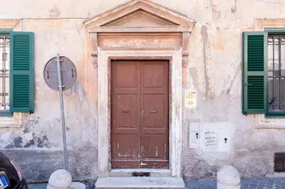 a wooden door on a building with green shutters at Beautiful Vatican in Rome