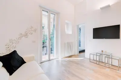 a white living room with a white couch and a tv at Beautiful Vatican in Rome