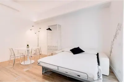 a white bedroom with a bed and a table at Beautiful Vatican in Rome