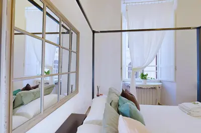a bedroom with a bed and two windows at Casa Vacanze BorgoVI House in Rome