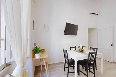 a white dining room with a white table and chairs at Casa Vacanze BorgoVI House in Rome