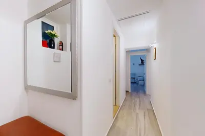 a hallway with a mirror on a white wall at Casa Vacanze BorgoVI House in Rome