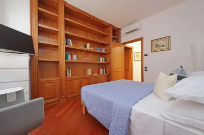 a bedroom with a bed and a book shelf at FleminHouse a soli 10 min da San Pietro in Rome