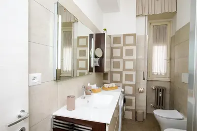 a bathroom with a sink and a toilet and a mirror at Aureliana House Roma in Rome