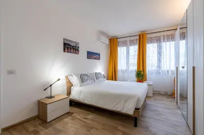 a bedroom with a white bed and some windows at La Casa di Marilù Vicino a Trastevere in Rome