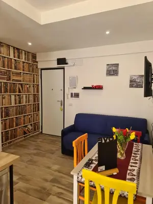a living room with a blue couch and a table with chairs at La Casa di Marilù Vicino a Trastevere in Rome