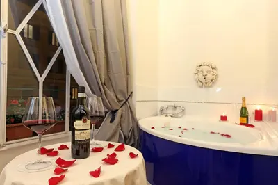 a bathroom with a glass of wine and a tub at Liberty Rome Suites - Liberty Collection in Rome