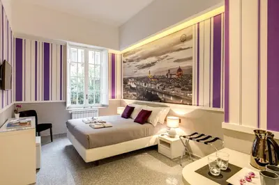a bedroom with a bed and a painting on the wall at Liberty Rome Suites - Liberty Collection in Rome