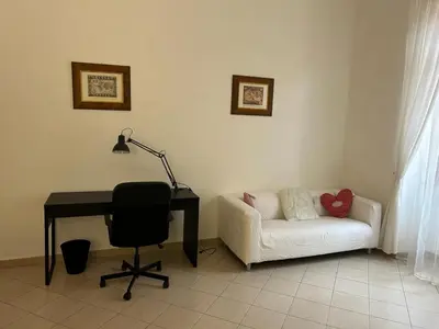 a desk and a chair in a room with a couch at Vatican Vittoria Suite in Rome