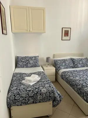 a bedroom with two beds with blue and white sheets at Vatican Vittoria Suite in Rome