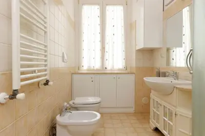 a white bathroom with a toilet and a sink at Delizioso apartment Porta Metronia Roma in Rome