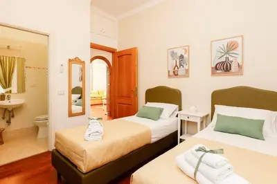 two beds in a room with a bathroom at Delizioso apartment Porta Metronia Roma in Rome