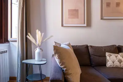 a living room with a couch and a vase on a table at Trastevering in Rome in Rome