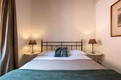 a bedroom with a bed with two lamps on both sides at Trastevering in Rome in Rome