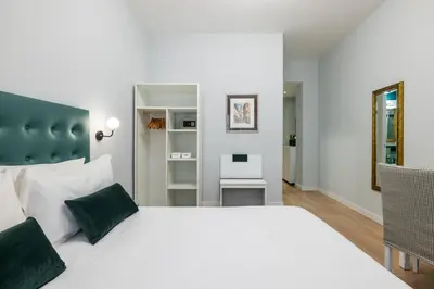 a bedroom with a large white bed with green pillows at Domus Bella Roma in Rome