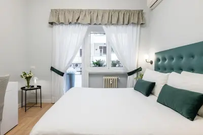 a bedroom with a white bed and a window at Domus Bella Roma in Rome