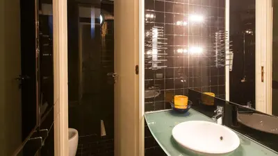 a bathroom with a sink and a toilet and a mirror at Rental in Rome Riari Garden in Rome