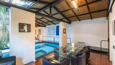 a living room with a glass table and a swimming pool at Rental in Rome Riari Garden in Rome
