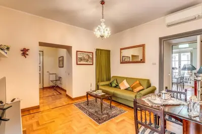 a living room with a green couch and a table at XX SETT: Flat by Barberini Trevi Fountain in Rome