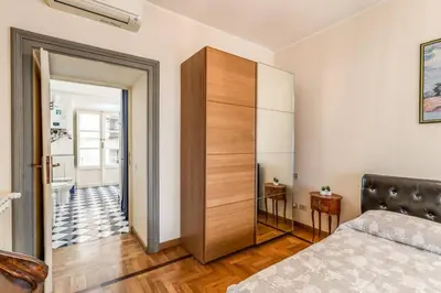a bedroom with a bed and a wooden closet at XX SETT: Flat by Barberini Trevi Fountain in Rome