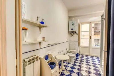 a bathroom with two toilets and a checkered floor at XX SETT: Flat by Barberini Trevi Fountain in Rome