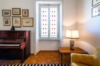 a living room with a piano and a lamp at Casa Emme in Rome