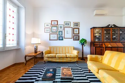 a living room with two yellow couches and a rug at Casa Emme in Rome