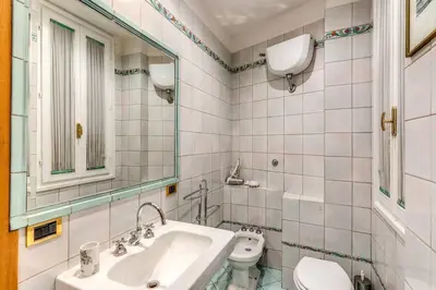 a bathroom with a sink and a toilet and a mirror at Cozy flat in Trevi Fountain in Rome
