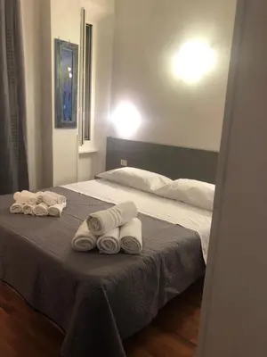 a bedroom with a bed with towels on it at ALMA Rooms Appia in Rome