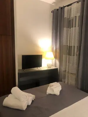 a bedroom with towels on a bed with a desk at ALMA Rooms Appia in Rome