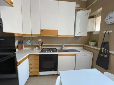 a kitchen with white cabinets and a stove top oven at Maresi Suite in Rome