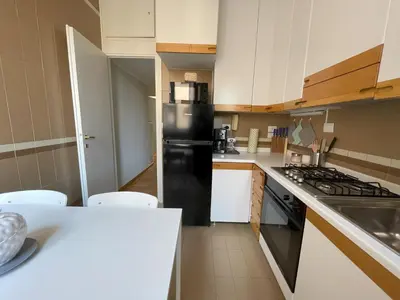 a kitchen with a black refrigerator and white cabinets at Maresi Suite in Rome