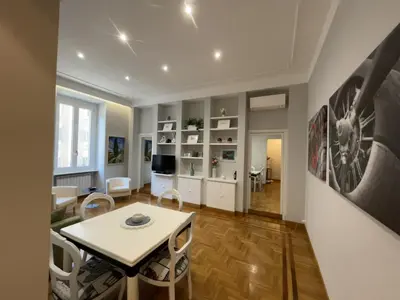 a living room with a table and a dining room at Maresi Suite in Rome