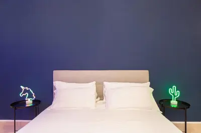 a bed with white sheets and two tables with cactuses on it at Maria Romita in Rome