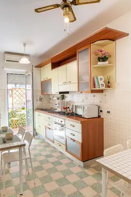 a kitchen with white cabinets and a table with chairs at Maria Romita in Rome