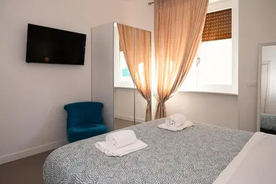 a bedroom with a bed and a blue chair at St Peter Boutique 1 in Rome