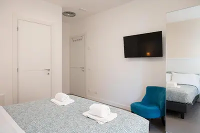 a hotel room with two beds and a blue chair at St Peter Boutique 1 in Rome