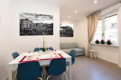 a dining room with a white table and blue chairs at St Peter Boutique 1 in Rome