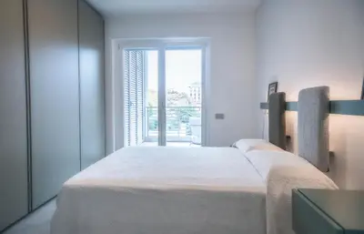 a white bedroom with two beds and a window at Sant'Agata in Trastevere in Rome
