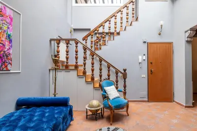 a living room with a blue couch and stairs at maison pelliccia Terrace in Rome