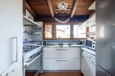 a kitchen with white appliances and a wooden ceiling at maison pelliccia Terrace in Rome